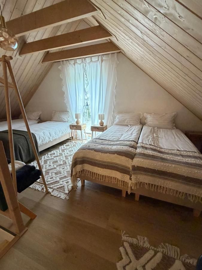 Dwa łóżka pod drewnianym skosem